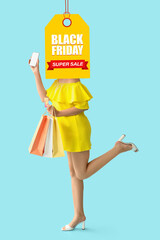 Young woman with credit card, mobile phone and shopping bags on blue background