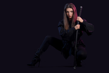 Beautiful sexy young woman with katana on dark background