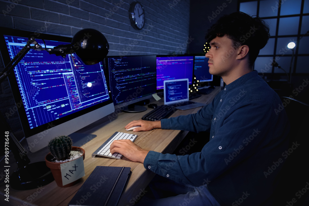 Aufkleber male programmer working with computer in office at night
