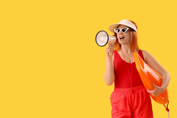Female lifeguard with rescue buoy shouting into megaphone on yellow background