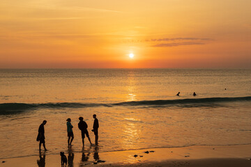 A group of people are chatting on the beach.
