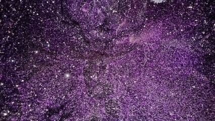 Texture of a glittery purple surface with varying shades and intensities of purple.
