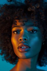 Fototapeta premium Portrait of a woman with curly hair and vibrant lighting, perfect for fashion, beauty, or editorial use in photography portfolios or advertising campaigns