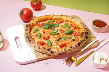 Board with tasty pizza Margarita and bowl of mozzarella on pink table