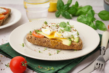 Plate of tasty sandwich with egg on light background