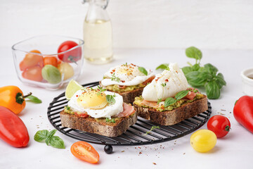 Grid of tasty sandwiches with egg on grey background