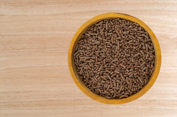 Small wood bowl filled with chocolate sprinkles on a tabletop.