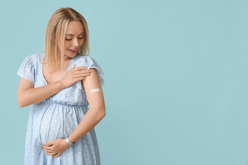 Young pregnant woman after vaccination on blue background