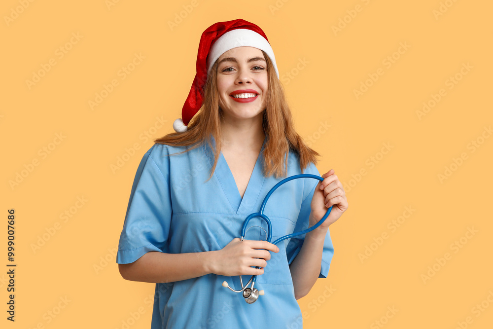 Canvas Prints Young female doctor in Santa hat on yellow background