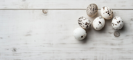 Obraz premium White wooden background with six quail eggs of different sizes on the right side
