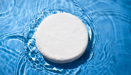 Empty white stone circle podium on calm blue water. Gentle sunlight. Minimalist product presentation