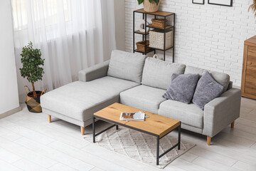Stylish interior of living room with comfortable sofa, coffee table and shelving unit