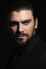 Strict male portrait. The guy in the classic black suit.