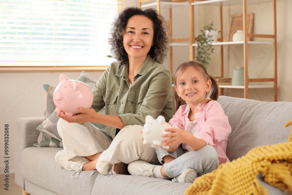 Sticker Little girl with her mother and piggy banks sitting on sofa at home