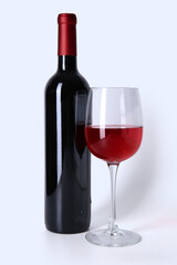 Bottle and glass of red wine isolated on white background