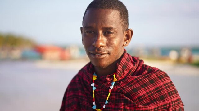 Portrait of Maasai man, traditional outfit, African warrior tribesman on beach. Tropical island beach in Tanzania. tourism destination in Africa. 