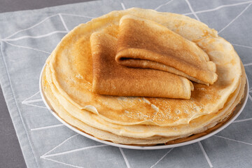 Stack of traditional russian pancakes blini on gray background. Homemade russian thin pancakes...