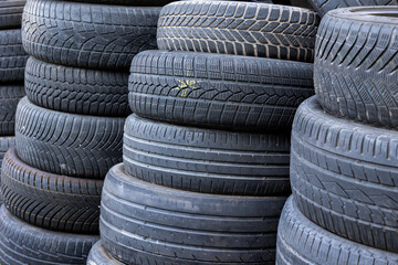 Stack of old, worn and damaged tires lying in a landfill. Decreased road safety and environmental pollution from rubber waste