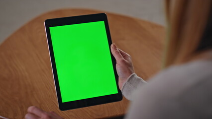 Unrecognizable businesswoman swiping green screen tablet at home close up.