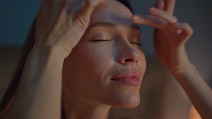Woman making facial massage at evening apartment close up. Girl massaging face 