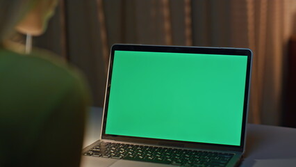 Late worker looking chroma key laptop working on project remotely close up.