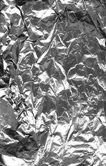 piece of crumpled shiny metallic paper with multiple shapes and cuts