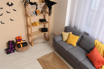 Interior of modern living room decorated for Halloween with shelving unit and sofa