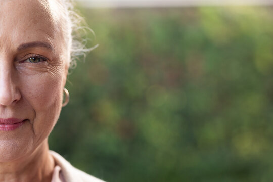 Smiling senior woman with hoop earring, close-up portrait outdoors, enjoying day, copy space, at hom