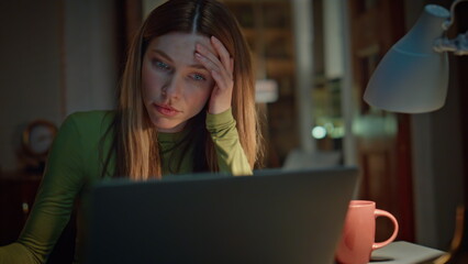 Fototapeta premium Overworked freelancer rubbing eyes looking on laptop screen late evening closeup