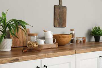 Interior of light kitchen with utensils on white counters, closeup