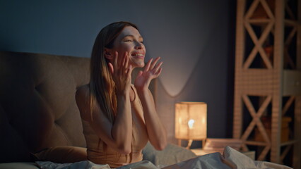 Girl massaging facial skin sitting bedroom evening closeup. Woman making massage