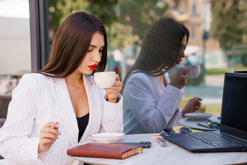 Elegant Business Woman Sipping Coffee in Stylish Office Setting with Reflections