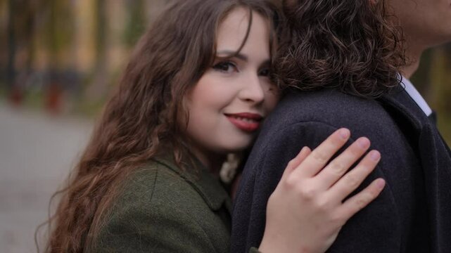 A loving couple shares a warm embrace among autumn foliage, capturing the beauty of love and connection