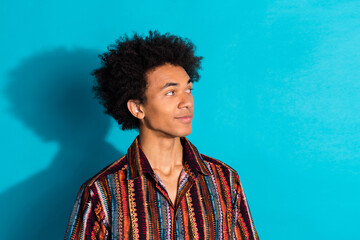 Photo portrait of young funky guy with curly hair wearing striped shirt curious looking for summer clothing sale isolated on cyan color background