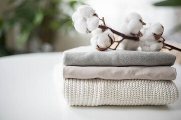 A neat stack of clean knitwear in neutral colors. Concept for sale, recycling, storage of clothing.