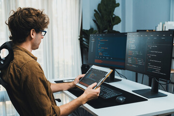 Working IT developer reading online software development information on document report surrounded...