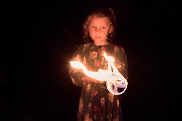 Petite fille tenant une lumi&egrave;re en mouvement dans l'obscurit&eacute;
