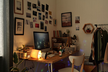 Workplace of modern home office manager with desktop computer surrounded by photoset on walls and...