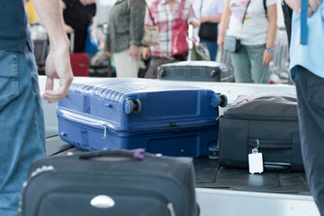 suitcases on a baggage carousel at an airport during a busy travel day