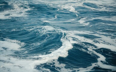 Vibrant blue ocean waves with white frothy surf on a restless sea.