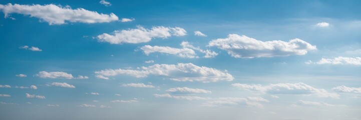 Fototapeta premium A serene daytime sky filled with fluffy white clouds against an azure blue backdrop.