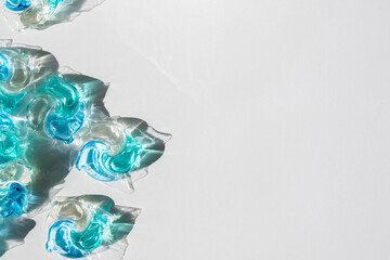 Washing gel capsule pods with laundry detergent on a pile of white cloth background