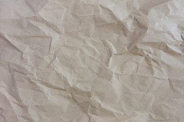 An abstract image of the texture of a crumpled up and wrinkled brown paper bag. 
