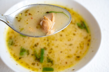 fish soup with vegetables and lemon in white bowl close-up