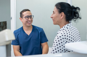 smiling dentist attends to an adult latina patient