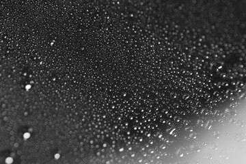 Macro shot of water droplet on reflective surface as background