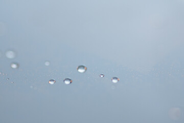 Macro shot of water droplet on reflective surface as background