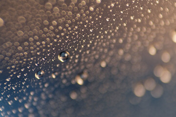 Macro shot of water droplet on reflective surface as background
