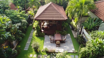 Obraz premium An aerial view of a lush tropical garden with a wooden gazebo and a patio set.