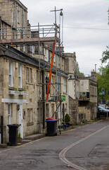 Bath England. A row of old terraced buildings with scaffolding erected  to facilitate essential repairs and maintenance in early spring.